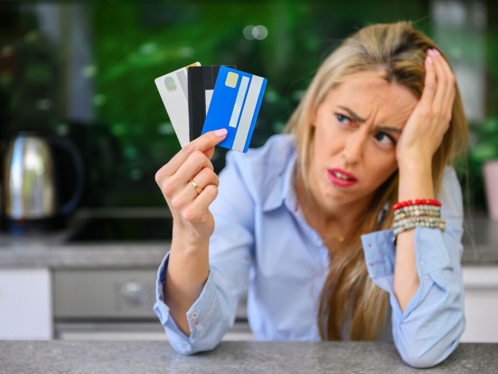A woman holding 3 credit and debit cards