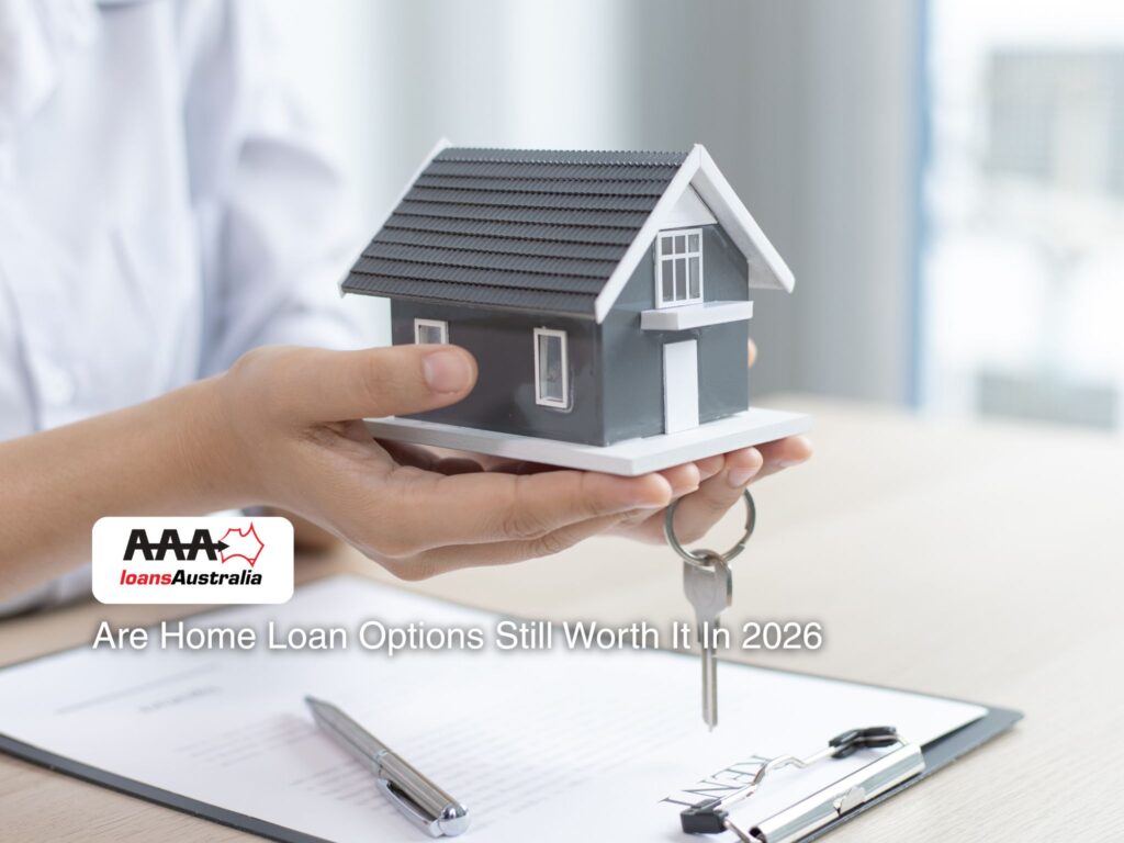 Hands holding a model house above documents showing home loan options in 2026