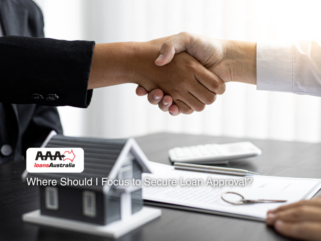 Handshake between client and adviser after securing loan approval, with small house model on table.